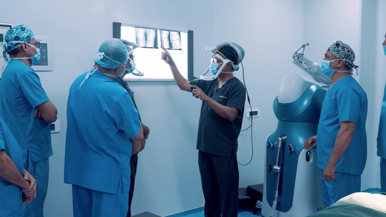 Dr Milind Patil reviewing knee X-rays beside the MAKO robot at Revival orthopaedic hospital in Thane